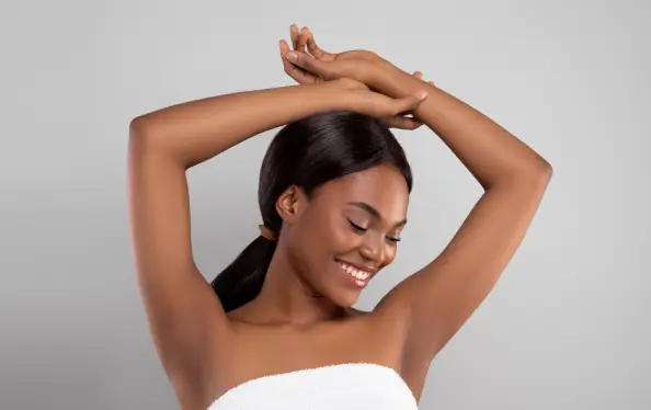 Armpit Depilation Concept. Happy Black Lady Looking At Her Smooth Underarms